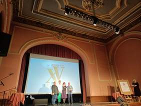 Cztery osoby na scenie, w tle wyświetla się napis Piętnastolecie Grupy Zet