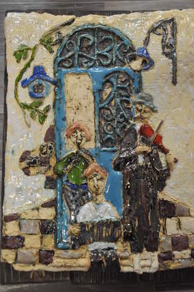 Pokaż zdjęcie: Trzech ulicznych muzykantów grających na flecie, harmonii oraz skrzypcach, stoją na tle niebieskich drzwi