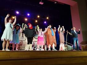 7 aktorów wpożegnalnej scenie, trzymają się za ręce podniesione do góry