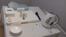 Pokaż zdjęcie: Sprzęt kuchenny przeznaczony dla osób z niepełnosprawnościami: czajnik, krajalnica, miska oraz toster.