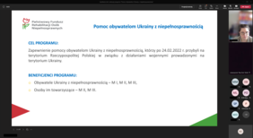 Pokaż zdjęcie: Slajd z prezentacji dot. programu "Pomoc obywatelom Ukrainy z niepełnosprawnością". Obok slajdu widoczne inicjały uczestników spotkania online