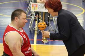 Grażyna Bogdańska - p.o. dyrektora Oddziału Podlaskiego PFRON wręcza puchar uczestnikowi zawodów. 