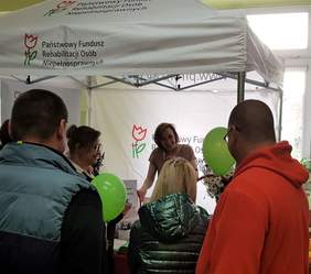 Pokaż zdjęcie: Uczestnicy Międzypokoleniowego Pikniku Rodzinnego w Powidzu przy stoisku Oddziału Wielkopolskiego PFRON