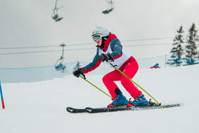 Narciarz alpejski, aura zimowa, biały śnieg, słoneczny dzień.