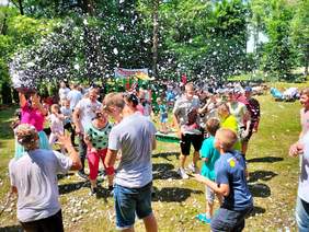 Pokaż zdjęcie: Grupa dzieci bawi się bańkami mydlanymi