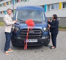 Pokaż zdjęcie: Niebieski bus z czerwoną kokarda na masce