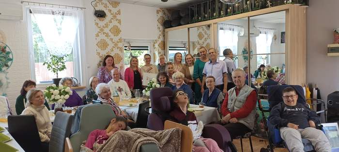 Pokaż zdjęcie: Uczestnicy ŚDS wraz z kadrą i Dyrektor Oddziału PFRON na okolicznościowym wspólnym zdjęciu w siedzibie placówki