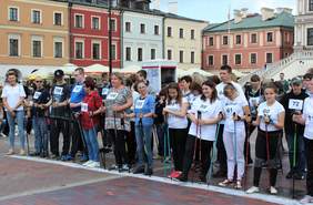Pokaż zdjęcie: Uczestnicy biegu w kategorii nordic walking ustawieni na starcie na Rynku Wielkim w Zamościu