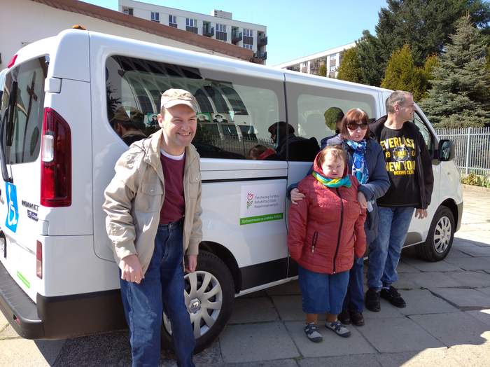 Pokaż zdjęcie: Czworo uśmiechniętych Uczestników WTZ os. Dywizjonu 303 pozuje na tle nowego samochodu