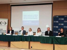 Pokaż zdjęcie: Sala konferencyjna KUL stół prezydialny przy którym siedzi osób, w tle prezentacja.