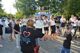 Pokaż zdjęcie: Uczestnicy uroczystości jubileuszowych podczas tańca. Uśmiechnięte osoby trzymają się za ręce i tańczą