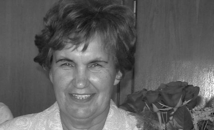 Czarno-białe zdjęcie uśmiechniętej kobiety trzymającej róże