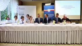 Organizatorzy spotkania i zaproszeni goście przy stole prezydialnym podczas spotkania konsultacyjnego