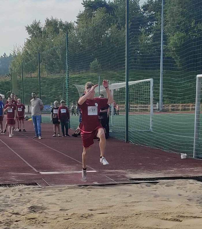Pokaż zdjęcie: Osoba z niepełnosprawnością w trakcie wyskoku w dal