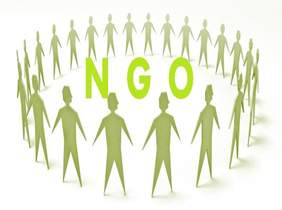 Pokaż zdjęcie: logo organizacji pozarządowych, po środku zamieszczono postacioe osób które stoją w kręgu w środku napis NGO w kolorze zielonym 