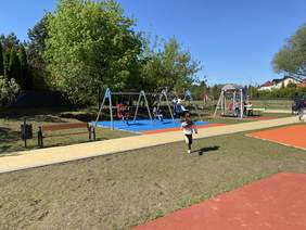 Pokaż zdjęcie: Na zdjęciu dzieci bawiące się na urządzeniach nowego placu zabaw dofinansowanego ze środków PFRON w ramach programu Dostępna Przestrzeń Publiczna