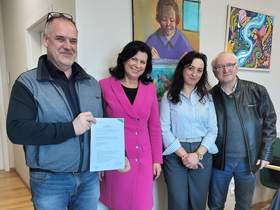 Dwie kobiety i dwóch mężczyzn pozują do zdjęcia, trzymają podpisaną umowę.