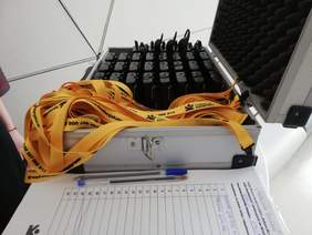 Pokaż zdjęcie: Stolik, na blacie stoi pojemnik ze słuchawkami