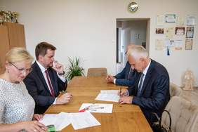 Pokaż zdjęcie: Przy stoliku w gabinecie podpisują umowę władze Powiatu i Dyrektor Oddziału PFRON