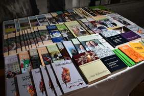 Pokaż zdjęcie: Na stoliku, w trzech rzędach ułożone są miesięczniki „Filantrop Naszych Czasów”. Z przodu można dostrzec również różne publikacje książkowe.