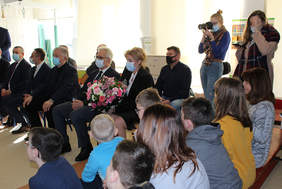 Pokaż zdjęcie: Grupa osób siedzących na spotkaniu, na pierwszym planie mężczyźni w garniturach