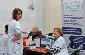 Pokaż zdjęcie: Stoisko WOMP oferujące bezpłatny pomiar ciśnienia i poziomu cukru we krwi 