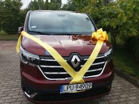 Pokaż zdjęcie: Zdjęcie samochodu marki Renault, bus w kolorze bordowym przewiązany wstążką