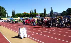 Uczestnicy zawodów, zebrani na stadionie na uroczystym otwarciu VII Toruńskiej Olimpiady Sportu Niepełnosprawnych 