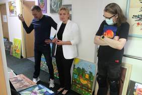 Pokaż zdjęcie: 3 osoby w tle prace plastyczne