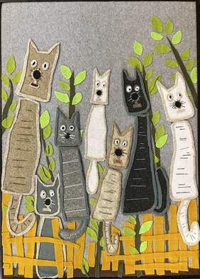 Pokaż zdjęcie: Praca wykonana z filcu. Pokazuje siedem kotów siedzących na żółtym płotku. Koty są całe w kolorach białych ,szarych , beżowych i czarnych. W tle gałązki z liśćmi. 
