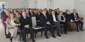 Pokaż zdjęcie: Zdjęcie zaproszonych gości siedzących na krzesełkach w Sali Kryształowej.