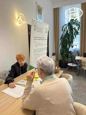 Dwie kobiety siedzące przy stole, w trakcie rozmowy