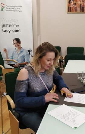 Pokaż zdjęcie: Regina Mynarska – ekspert ds. dostępności (Fundacja Siódmy Zmysł) podczas podpisania umowy w siedzibie Oddziału Małopolskiego PFRON