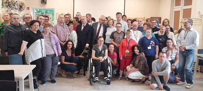Pokaż zdjęcie: Grupa uśmiechniętych osób pozujących do zdjęcia