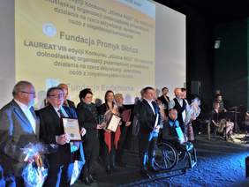 Grupa osób stojących na scenie