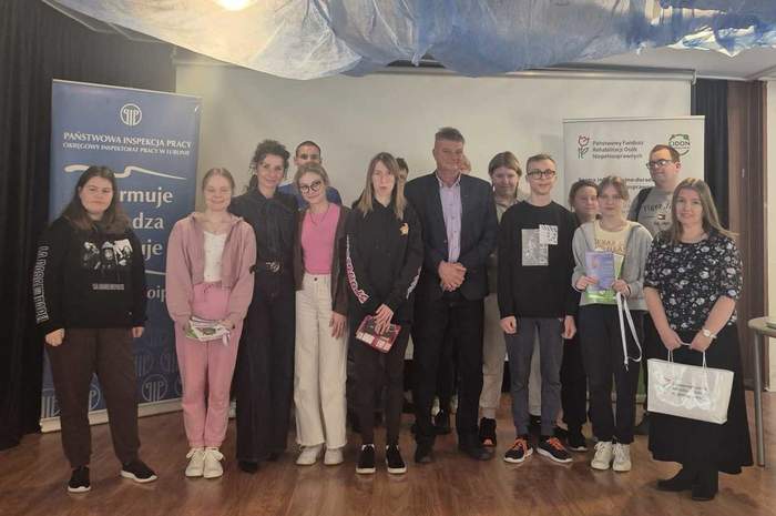 Pokaż zdjęcie: Do pamiątkowej fotografii pozują uczestnicy spotkania, młodzież oraz eksperci z Inspekcji Pracy oraz PFRON.