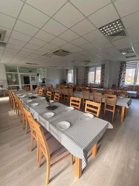 duża sala ze stołami nakrytymi do posiłku