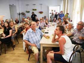 Pokaż zdjęcie: Grupa osób siedząca przy stolikach