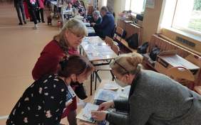 Pokaż zdjęcie: na zdjęciu pracownik Oddziału udziela informacji dwóm osobom, które stoją przy stoisku PFRON, na którym umieszczone są ulotki i informatory