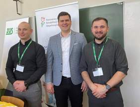 Pokaż zdjęcie: Trzech młodych mężczyzn w koszulach stoi i uśmiecha się