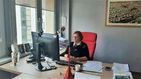 Dyrektor Oddziału - Aleksandra Gierej - siedzi przy biurku, podczas spotkania on line, przed nią stoi monitor