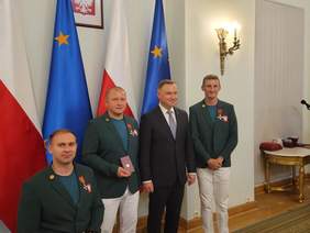 Pokaż zdjęcie: 3 zawodników (w tym jeden na wózku inwalidzkim) i 1 trener "Start" Gorzów stoją obok Prezydenta Polski Adrzeja Dudy na tle flag Polski i Unii Europejskiej w sali Pałacu Prezydenckiego