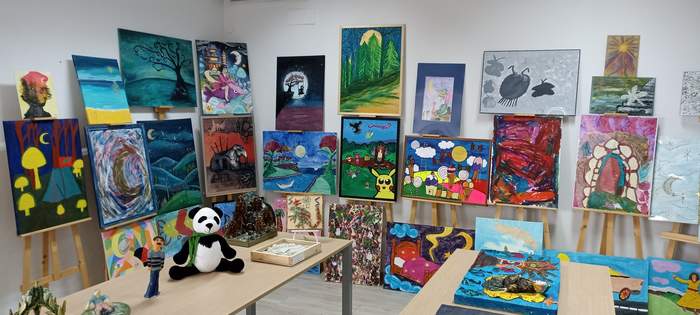 Pokaż zdjęcie: Prace plastyczne, wykonane różnymi technikami, widoczne w pomieszczeniu Oddziału