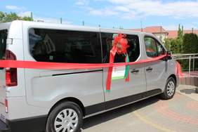 Pokaż zdjęcie: Bus w kolorze srebnym ,który pzrewiązany jest wstążkami w kolorze czerwonym