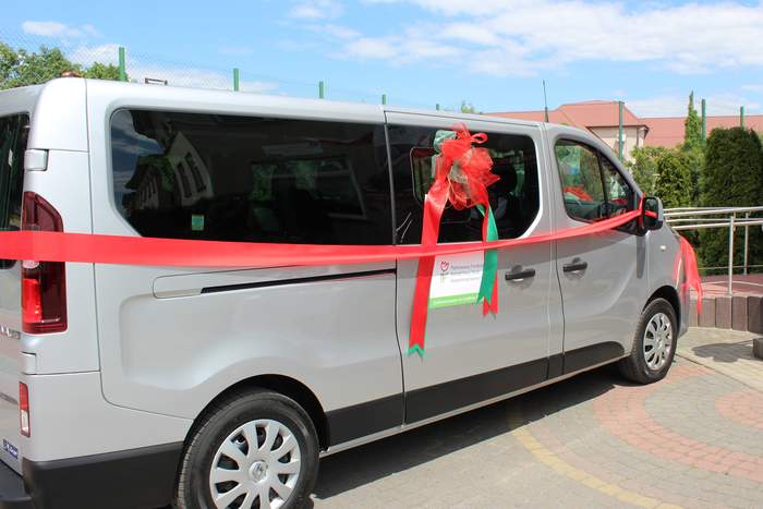 Pokaż zdjęcie: Bus w kolorze srebnym ,który pzrewiązany jest wstążkami w kolorze czerwonym