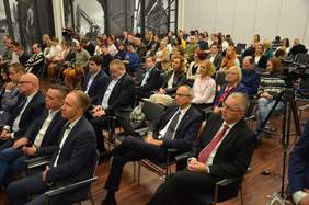 Pokaż zdjęcie: na zdjęciu dużo osób siedzi i słucha prelegenta na konferencji Niepełnosprawni na rynku pracy 