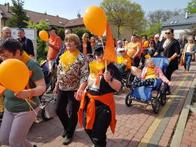 Uczestnicy marszu, dorośli, młodzież, dzieci idą ulicą w Jarosławiu