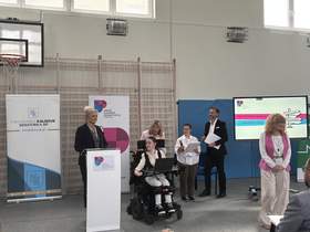 Grupa osób w tym pięć kobiet oraz jeden mężczyzna, wszyscy elegancko ubrani i trzymający mikrofony. Wśród nich są Senator RP Ewa Monika Kaliszuk oraz Dyrektor ZPE Agnieszka Jabłońska. Pozostałe osoby to kadra prowadząca wydarzenie. W tle widoczne są banery informacyjne organizatorów oraz duży ekran z oficjalnym logotypem i nazwą targów: „Kierunek Przyszłość”. 