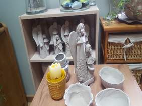 Pokaż zdjęcie: na zdjęciu gliniane aniołki w kolorze naturalnym oraz misy gliniane wykonane przez uczestników WTZ w Wieruszowie