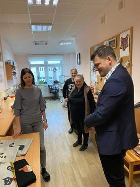 Pokaż zdjęcie: Dyrektor PFRON ogląda koszulki z nadrukami bajkowych postaci